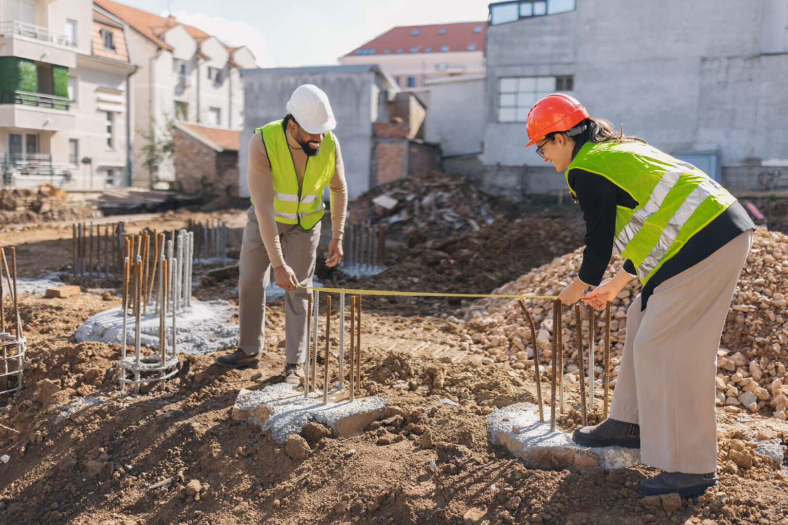 Construction workers measuring at a building site.