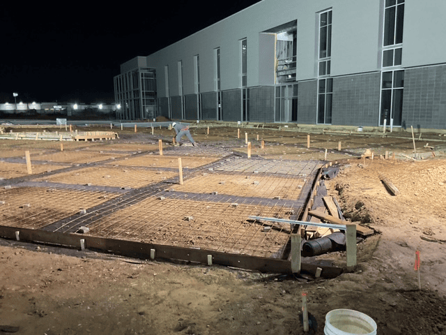 Two workers applying finishing touches to concrete